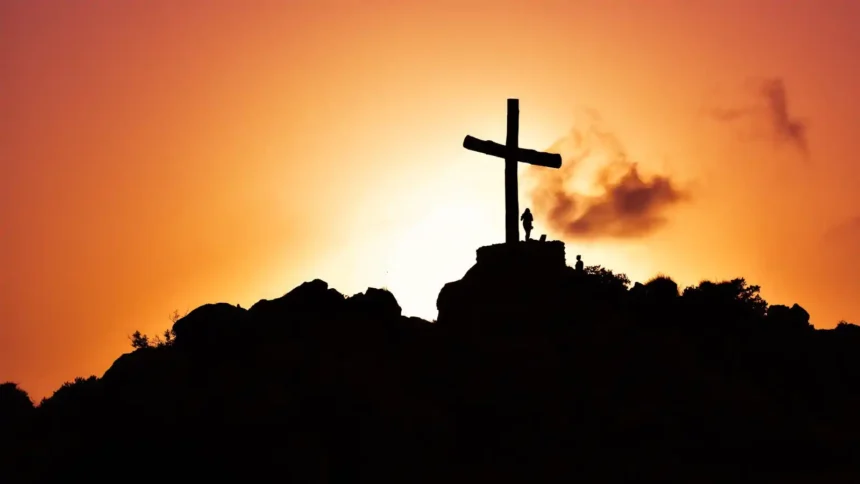 Human Standing Beside Crucifix Statue on Mountain