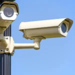 White 2 Cctv Camera Mounted on Black Post Under Clear Blue Sky