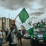 social studies - a group of people walking down a street holding a flag