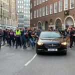 media reporters chasing black vehicle on road