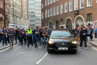 media reporters chasing black vehicle on road