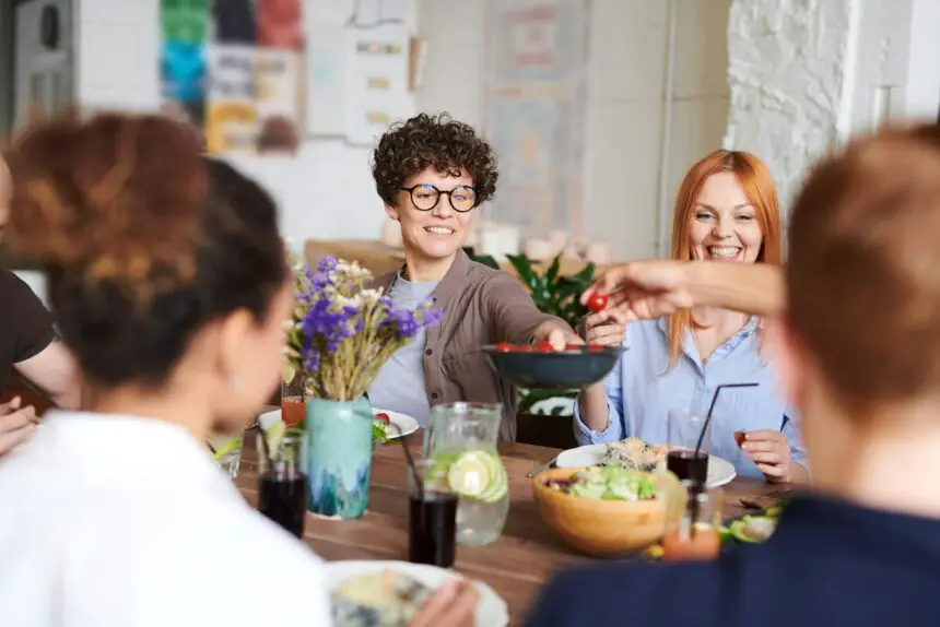 Family values: A happy group of friends and family enjoying a meal together indoors. Perfect for themes of togetherness and joy.