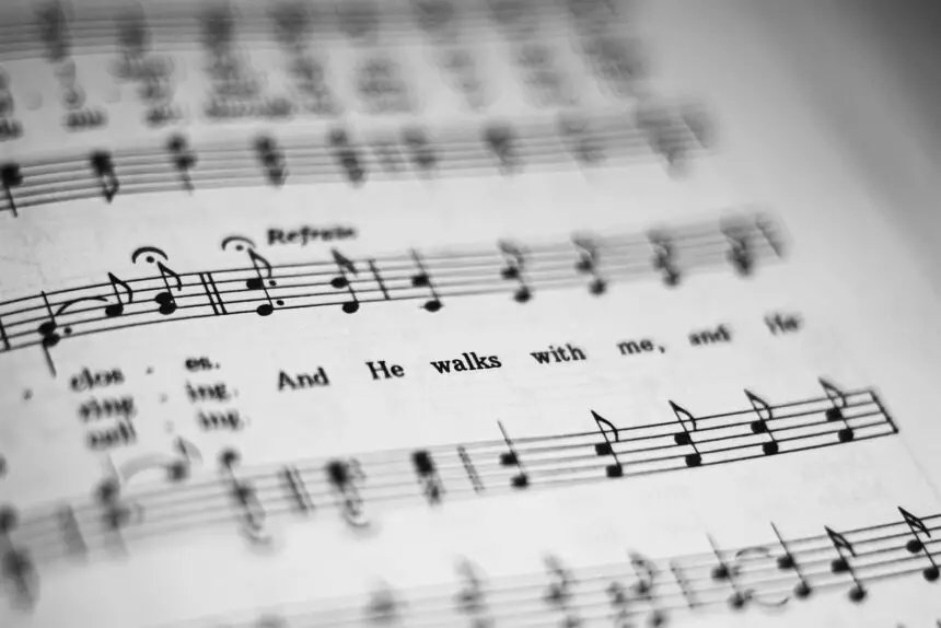 Putting Lines and Text to Music: Close-up of black and white sheet music featuring musical notes and lyrics in focus.