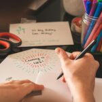 Card Making and Materials: A creative workspace featuring colorful markers, scissors, and a handwritten card reading 'Crafting is Life!'.