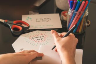 Card Making and Materials: A creative workspace featuring colorful markers, scissors, and a handwritten card reading 'Crafting is Life!'.