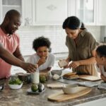 function of each family member: A joyful family enjoys preparing a healthy meal together in their modern kitchen.