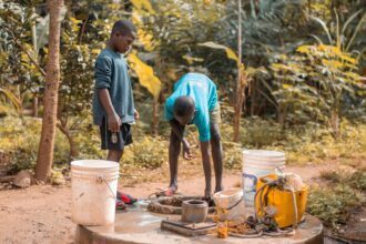 Personal and Family Resources: Two children collecting water from a well in a forest setting, featuring vibrant nature.