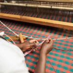 introduction to weaving: person in white pants lying on red and white hammock